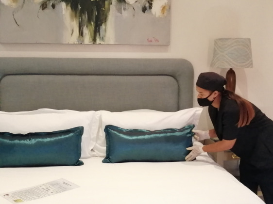housekeeper making a hotel bed